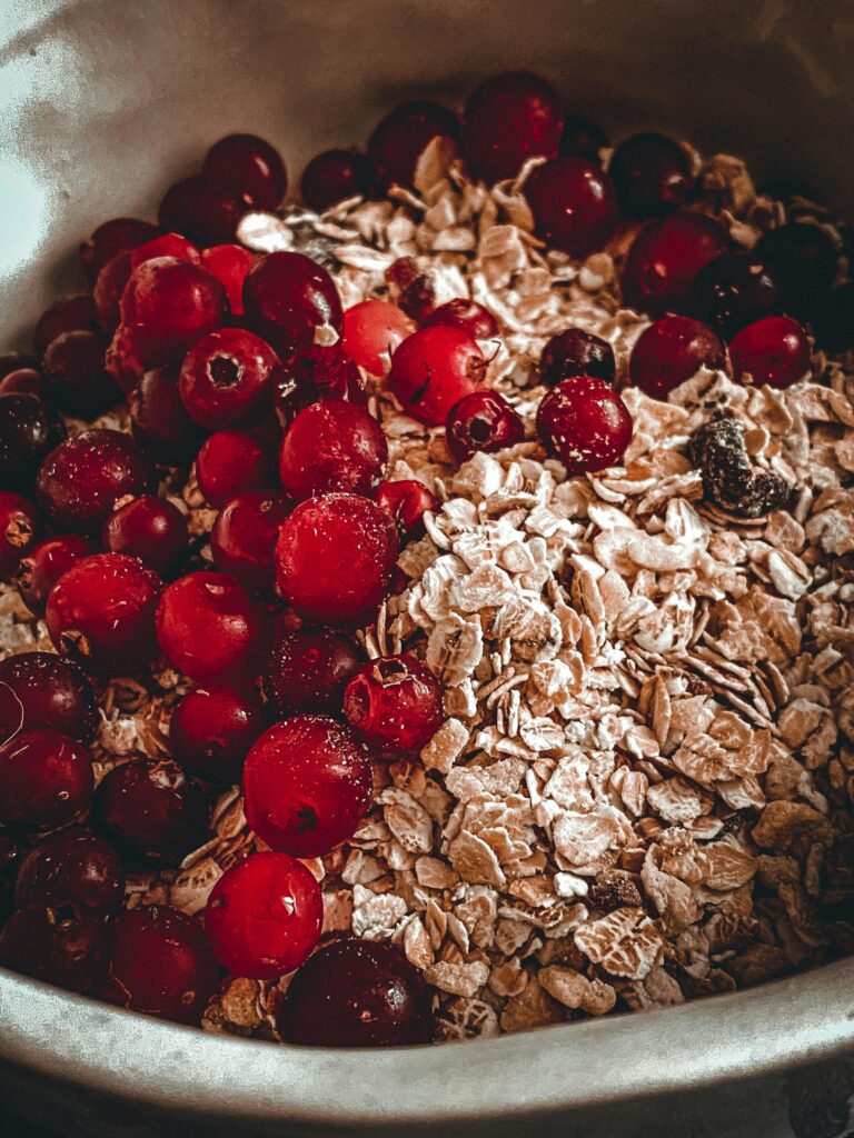 A close-up of fresh red berries and rolled oats in a bowl, perfect for breakfast.