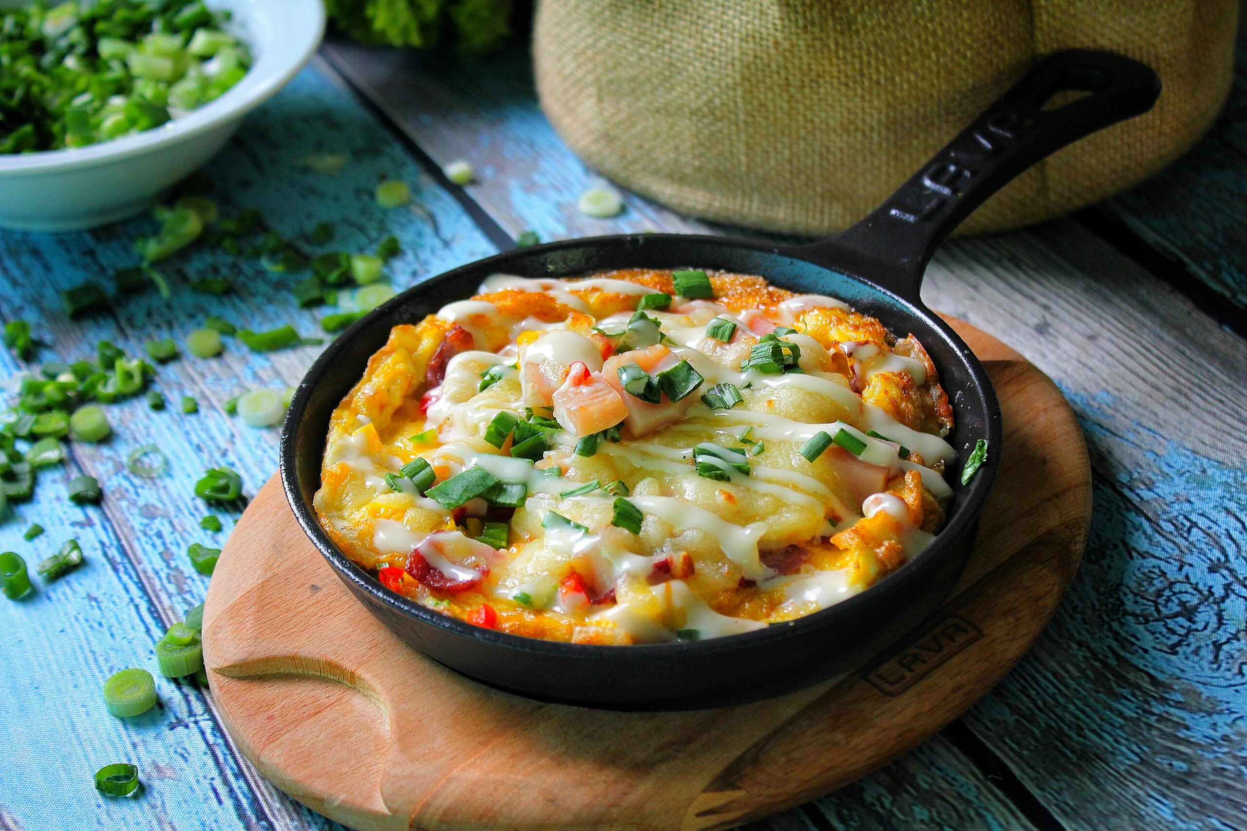 Delicious frittata with cheese and vegetables in a rustic skillet, ideal for a hearty breakfast.